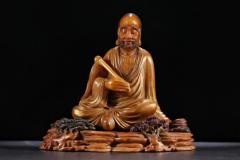 玩家旧藏，田黄石浮尘罗汉摆件  规格：高16cm长16.5cm宽9cm重1613g 藏品以高山田黄石为材，大料雕刻，刻画罗汉形象传神，开脸慈祥，衣饰飘逸，手持浮尘，等级高，栩栩如生，刀功老辣，整器包浆厚重，用料上乘，实为石雕之美。