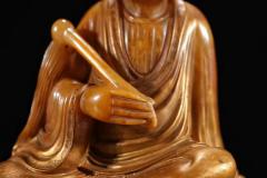 玩家旧藏，田黄石浮尘罗汉摆件  规格：高16cm长16.5cm宽9cm重1613g 藏品以高山田黄石为材，大料雕刻，刻画罗汉形象传神，开脸慈祥，衣饰飘逸，手持浮尘，等级高，栩栩如生，刀功老辣，整器包浆厚重，用料上乘，实为石雕之美。